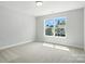 Bright bedroom with a large window offering neighborhood views and neutral carpet at 5103 Heathland Dr # 50, Charlotte, NC 28215