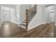 Beautiful entryway with hardwood floors, stairs with dark wood railing, and white wainscoting at 5103 Heathland Dr # 50, Charlotte, NC 28215