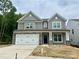 Charming two-story home with gray siding, stone accents, and a two-car garage at 5103 Heathland Dr # 50, Charlotte, NC 28215