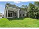 Large backyard view of the house featuring gray siding, white trim, and lush green lawn at 5103 Heathland Dr # 50, Charlotte, NC 28215