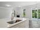 Open-concept kitchen with a large island, stainless steel sink, and view of the fireplace at 5103 Heathland Dr # 50, Charlotte, NC 28215