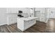 Bright kitchen features stainless steel appliances, white cabinetry, and a large island with a sink at 5103 Heathland Dr # 50, Charlotte, NC 28215