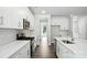 Bright kitchen features stainless steel appliances, white cabinetry, quartz countertops and wood flooring at 5103 Heathland Dr # 50, Charlotte, NC 28215