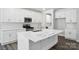 Bright kitchen features stainless steel appliances, white cabinetry, and a large island with a sink at 5103 Heathland Dr # 50, Charlotte, NC 28215