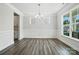 Open-concept living room with gray flooring, white walls, and bright windows at 5103 Heathland Dr # 50, Charlotte, NC 28215