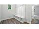 Hall tree in the mudroom features shiplap, bench, and storage cubbies with wood-look flooring at 5103 Heathland Dr # 50, Charlotte, NC 28215