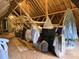 Attic with visible wooden beams, a door, and items covered with plastic and tarps at 534 Ballymote Ct, Matthews, NC 28104