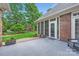 Charming back patio area with gray-flecked floor, brick accents, and lush greenery, creating a private outdoor space at 534 Ballymote Ct, Matthews, NC 28104