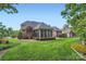 Manicured lawn and landscaping surround this brick home with a screened porch, creating a tranquil backyard retreat at 534 Ballymote Ct, Matthews, NC 28104
