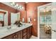 Bathroom with a double sink vanity, decorative walls, and a view into an adjacent bedroom at 534 Ballymote Ct, Matthews, NC 28104