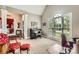 Bright living room with a large window and piano featuring elegant red armchairs at 534 Ballymote Ct, Matthews, NC 28104