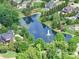 Aerial view shows a neighborhood pond with a fountain and well-manicured lawns at 6004 Quintessa Dr, Matthews, NC 28104