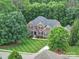 Beautiful aerial view of a brick two-story home with manicured lawn and mature trees at 6004 Quintessa Dr, Matthews, NC 28104