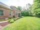 Expansive backyard with manicured lawn, garden beds, and mature trees at 6004 Quintessa Dr, Matthews, NC 28104