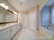 Bright bathroom with double vanity, a soaking tub, and marble tile flooring at 6004 Quintessa Dr, Matthews, NC 28104