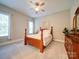 Bright bedroom with a four-poster bed, ceiling fan, carpeted floors, and a large window at 6004 Quintessa Dr, Matthews, NC 28104