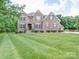 Beautiful two-story brick home featuring blue shutters and a meticulously maintained lawn at 6004 Quintessa Dr, Matthews, NC 28104