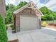 A detached, one-car garage features brick and stone construction at 6004 Quintessa Dr, Matthews, NC 28104
