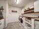 Well-organized laundry room with washer, dryer, shelving, and folding counter at 6004 Quintessa Dr, Matthews, NC 28104