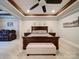 Serene main bedroom featuring a large bed, ceiling fan, tray ceiling, and comfortable seating area at 6004 Quintessa Dr, Matthews, NC 28104