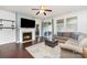 Cozy living room with a fireplace, ceiling fan, dark wood floors, and a sliding glass door at 7113 Meridale Forest Dr, Charlotte, NC 28269