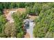 Aerial view of a home surrounded by lush trees, revealing its private setting and extended driveway at 720 Cricket Ln, Mt Ulla, NC 28125