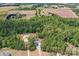 Aerial view showcases private property with a home nestled in nature, close to rural farmland at 720 Cricket Ln, Mt Ulla, NC 28125