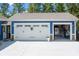 Attached two-car garage with white doors, complemented by landscaping for a cohesive exterior look at 720 Cricket Ln, Mt Ulla, NC 28125