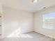 A bright bedroom with neutral carpet, natural light, and a minimalistic interior design at 8286 Ashvale Nw St, Concord, NC 28027