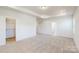 Spacious bedroom with neutral carpet, tray ceiling, and doorways to the bathroom and closet at 8286 Ashvale Nw St, Concord, NC 28027