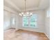 Dining room features a modern chandelier, wainscoting, hardwood floors, and natural light from large windows at 8286 Ashvale Nw St, Concord, NC 28027