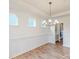 Dining room features a modern chandelier, wainscoting, light hardwood floors and large windows at 8286 Ashvale Nw St, Concord, NC 28027