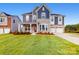 Charming two-story home boasts stone accents, blue siding, well-manicured lawn, and attached two car garage at 8286 Ashvale Nw St, Concord, NC 28027
