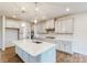 Modern kitchen with a large center island, white countertops and cabinetry, pendant lighting, and stainless appliances at 8286 Ashvale Nw St, Concord, NC 28027