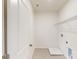 Well-lit laundry room with a utility sink, tiled flooring, and a wire shelf for extra storage at 8286 Ashvale Nw St, Concord, NC 28027