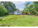 A spacious backyard with lush lawn, tall shade trees, and a wooden deck at 917 Laye St, Belmont, NC 28012