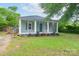Charming home with light blue siding, a cozy screened-in porch, and a well-maintained yard at 917 Laye St, Belmont, NC 28012