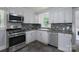 Bright kitchen featuring stainless appliances, stylish backsplash, and ample cabinet space at 917 Laye St, Belmont, NC 28012