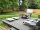 Outdoor deck featuring a dining table with chairs, lounge chairs, and a storage shed surrounded by a wooden privacy fence at 9207 Branson Ct, Charlotte, NC 28210
