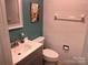 Bathroom with tiled walls, painted accent wall, toilet, vanity with faucet and mirror at 9207 Branson Ct, Charlotte, NC 28210