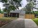 Single-story home featuring brick accents, a one-car garage, and a long driveway, complemented by a newly installed wooden fence at 9207 Branson Ct, Charlotte, NC 28210