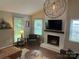 Bright living room featuring a fireplace, large windows, and a stylish light fixture at 9207 Branson Ct, Charlotte, NC 28210