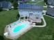 Aerial view of a home with a solar roof, large deck, and an inviting kidney-shaped pool at 100 Oakwood Meadow Dr, Mooresville, NC 28115