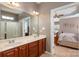 Bathroom featuring a double vanity, walk-in shower, and an open view to the main bedroom at 100 Oakwood Meadow Dr, Mooresville, NC 28115