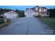 Exterior of a house with a long driveway, three-car garage, landscaped lawn, and nighttime lighting at 100 Oakwood Meadow Dr, Mooresville, NC 28115