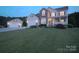 Charming two-story home with manicured lawn and separate garage at twilight at 100 Oakwood Meadow Dr, Mooresville, NC 28115