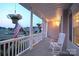 Charming front porch featuring a rocking chair, American flag, and hanging flower baskets at 100 Oakwood Meadow Dr, Mooresville, NC 28115
