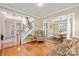 Inviting living room with hardwood floors, staircase, columns and an open dining room at 100 Oakwood Meadow Dr, Mooresville, NC 28115