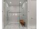 Modern glass shower with marble-style tile and a wooden bench at 10201 Laurier Ln, Huntersville, NC 28078