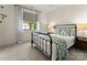 Cozy bedroom with a black metal bed frame, patterned bedding, and a sunny window view at 10201 Laurier Ln, Huntersville, NC 28078